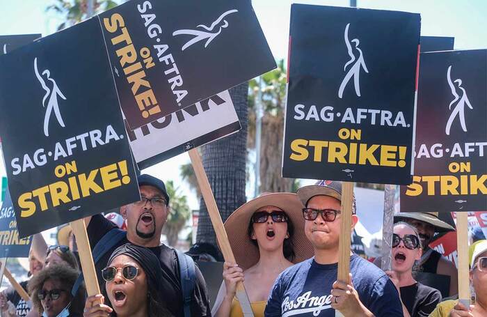 Striking writers and actors walk with pickets outside Sunset Bronson studios in Los Angeles in July. Photo: Shutterstock