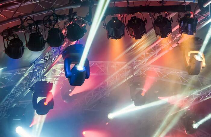 Multiple spotlights on a stage lighting rig. Photo: Shutterstock