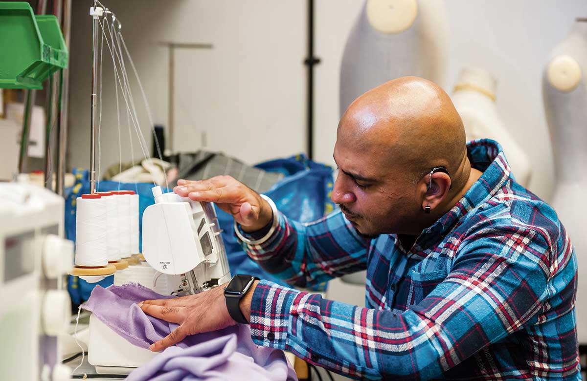 A member of a design team uses an overlocker to modify a garment in the costume room of a theatre. Photo: Alex Brenner/Tiata Fahodzi